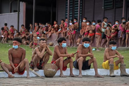 Los miembros de la etnia yanomami llevan máscaras faciales en un cuartel militar, donde se están realizando pruebas para COVID-19, en la tierra indígena de Surucucu, en Alto Alegre, estado de Roraima, en Brasil.,