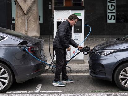 Un conductor de vehículo eléctrico usa un punto de carga de Barcelona Endolla.

