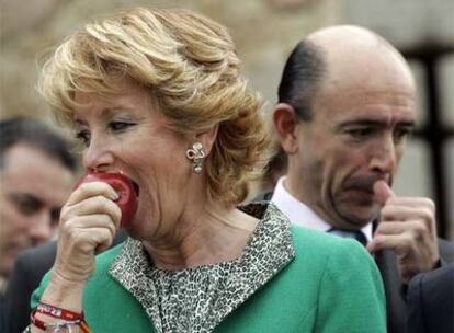 Esperanza Aguirre posó ante las cámaras mordiendo una manzana; detrás, Manuel Lamela