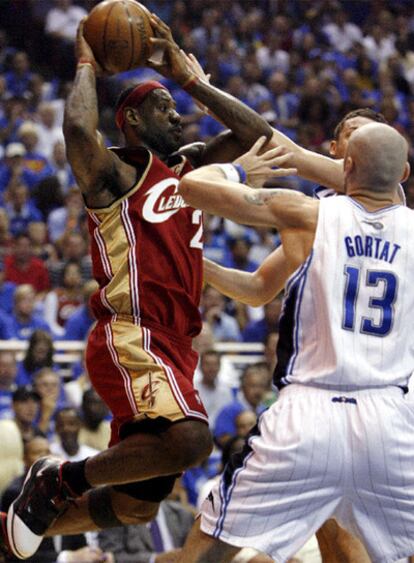 LeBron James hace un pase por encima de Marcin Gortat.