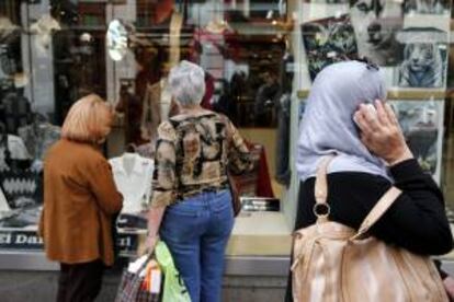 Varias personas pasan con bolsas de compras ante una de las tiendas de la céntrica calle Preciados de Madrid. EFE/Archivo