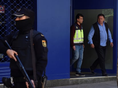 El presidente del Huesca, Agustín Lasaosa, junto a un policía a su salida de las oficinas del club tras ser detenido en mayo de 2018 durante la Operación Oikos.