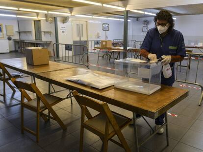 Una trabajadora desinfecta una urna para las elecciones catalanas en un colegio de Girona.