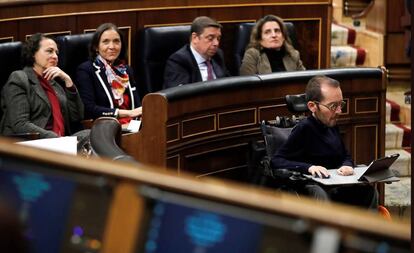 El diputado de Unidas Podemos, Pablo Echenique (derecha), sigue la intervención del candidato a presidente del Gobierno, Pedro Sánchez.