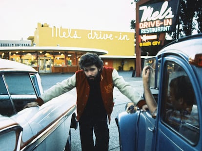 George Lucas posa entre dos coches durante el rodaje de 'American Graffiti', en San Francisco en 1973.