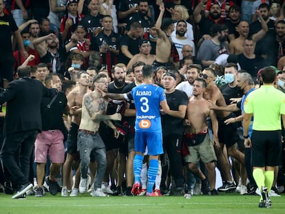 Álvaro, jugador del Marsella, se enfrenta a ultras del Niza que invadieron la cancha durante el partido de liga entre los dos equipos que fue suspendido ayer.