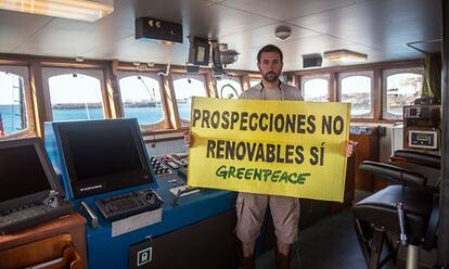 Un tripulante del Arctic Sunrise muestra una pancarta en defensa de la protesta pacífica