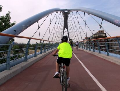 Un ciclista atraviesa el puente sobre la A-2 al final de la Avenida de América.