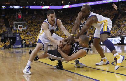 Parker, de los Spurs, intenta mantener el baln ante Thompson y Landry, de Golden State.