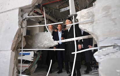 El presidente israelí, Isaac Herzog, en el lugar de impacto de un misil iraní, este domingo en Ness Ziona