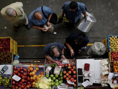 Clientes contam bolívares em um mercado de Caracas.