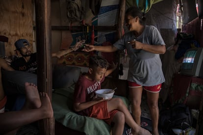 Uno de los cinco hijos de Cleide de Souza Nascimento come un plato donado por los programas de suplementos alimenticios en Brasil.