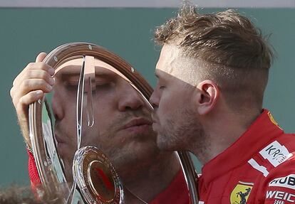 O piloto alemão da Ferrari Sebastian Vettel beija seu troféu após ganhar a primeira corrida da temporada no Grande Prêmio da Austrália, em Melbourne, o 25 de março de 2018