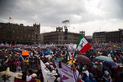 Partidarios de López Obrador se protegen con sombrillas y capasplásticas de la lluvia. 