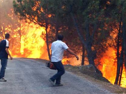 La virulencia de las llamas impide a dos vecinos de San Miguel (Ourense) acudir a una casa amenazada por el incendio.