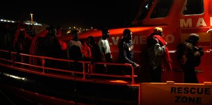 Un grupo de inmigrantes africanos esperan en el puerto de Motril, luego de que la embarcación en la que viajaban fuera interceptada por los guardacostas españoles ayer por la noche.