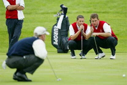 Sergio García y Lee Westwood, a la derecha, observan cómo calcula David Duval la pendiente del <b></b><i>green </i><b>del hoyo 10 en los </b><b></b><i>fourballs</i><b>, ayer por la mañana.</b>