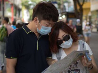 Turistas en Seúl se protegen con mascarillas este jueves.