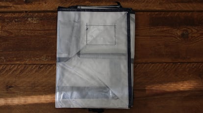 Bolsas de plástico para guardar ropa sobre una mesa de madera.