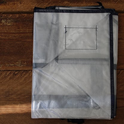 Bolsas de plástico para guardar ropa sobre una mesa de madera.