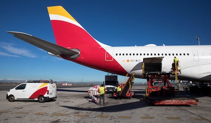 Personal de tierra de Iberia carga un Airbus330-200 con destino Bolivia en el aeropuerto de Barajas, en 2022.