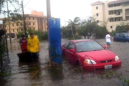 Habitantes de Cancún en una calle anegada durante el paso del huracán Wilma.