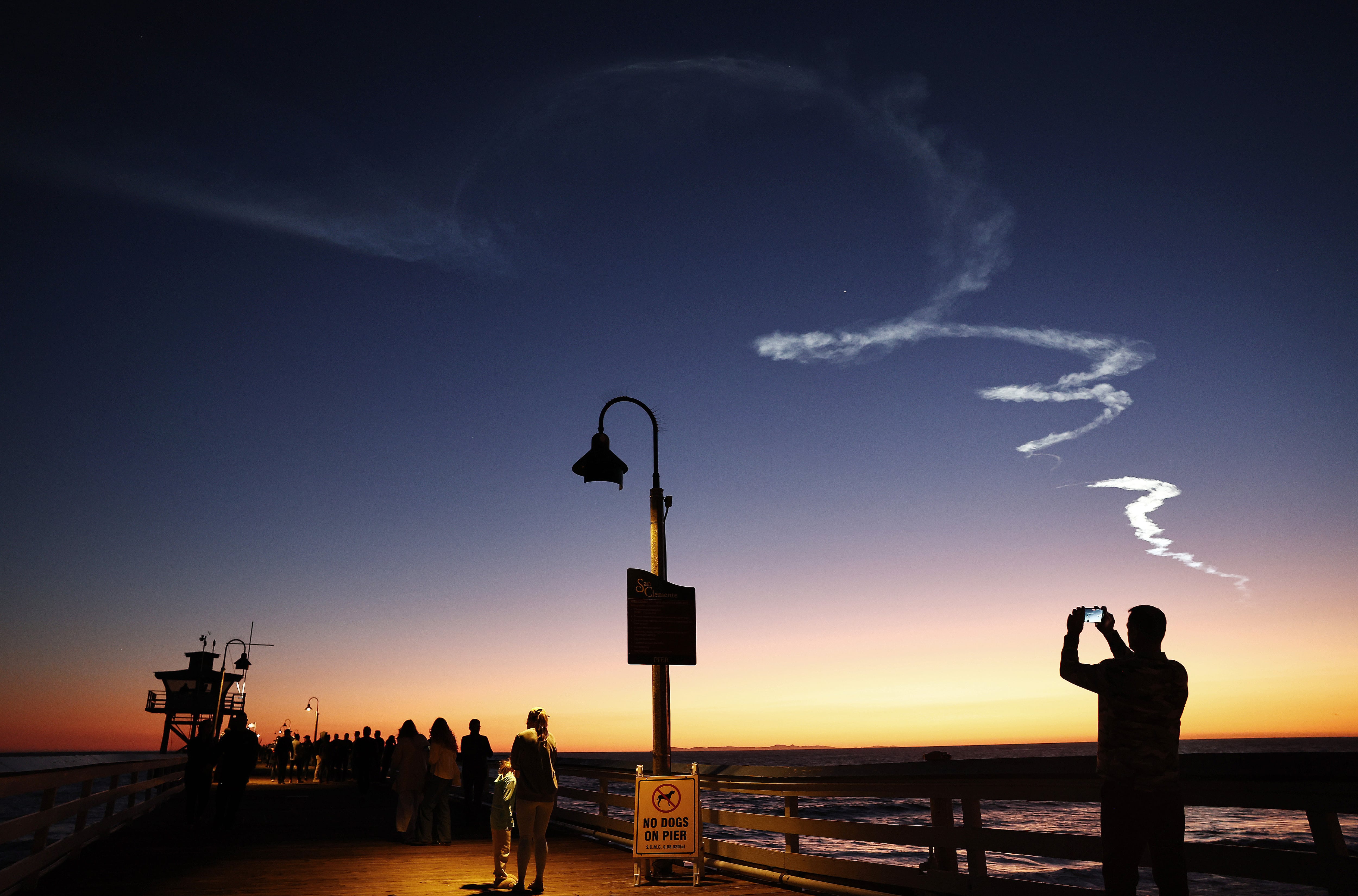 Varias personas contemplan el despegue de un cohete de SpaceX desde la base aérea de Vandenberg (EE UU) el 18 de marzo de 2024.