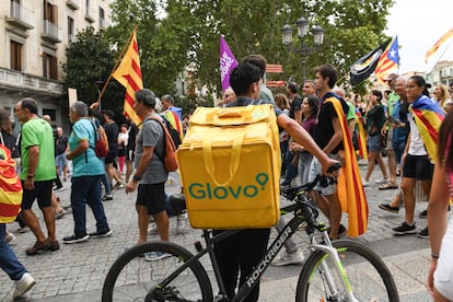 Un trabajador de Glovo observa a los manifestantes en la Diada de Girona.