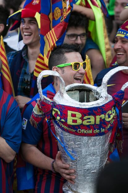 Aficionats amb una copa simulada a les mans esperen els jugadors.