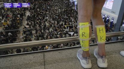 Una manifestante con un cartel de 'Free Hong Kong' en sus piernas ante los manifestantes que bloquearon el aeropuerto de Hong Kong, el 11 de agosto de 2019.