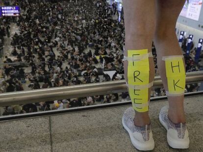 Una manifestante con un cartel de 'Free Hong Kong' en sus piernas ante los manifestantes que bloquearon el aeropuerto de Hong Kong, el 11 de agosto de 2019.