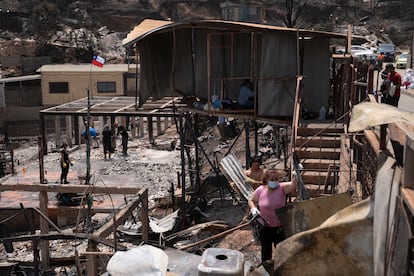 Personas retiran escombros desde una casa en el sector de Achupallas afectada por incendios forestales de Viña del Mar, este domingo.