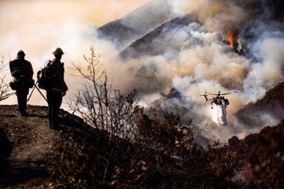 Equipes de bombeiros tratam de conter o fogo, na segunda-feira em Los Angeles. O estado da Califórnia virou uma fogueira no domingo, pronta para queimar e com sua população em alerta. A sensação de perigo iminente de norte a sul foi alimentada durante uma semana por temperaturas extremas para esta época do ano, ventos fortes e os avisos constantes das empresas de eletricidade de que poderiam cortar a luz para milhões de pessoas a qualquer momento, diante do perigo de que sua infraestrutura precária causaria uma faísca fatal, como já aconteceu várias vezes.