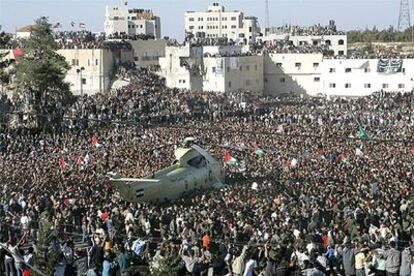 Miles de palestinos se arremolinan en torno al helicóptero que trasladaba el féretro de Arafat, justo después de su aterrizaje en Ramala.