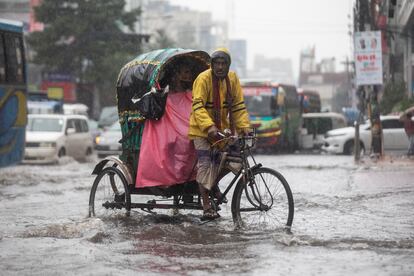 Un hombre pedaleaba en diciembre en una calle anegada por el ciclón Jawad, en Daca (Bangladés).