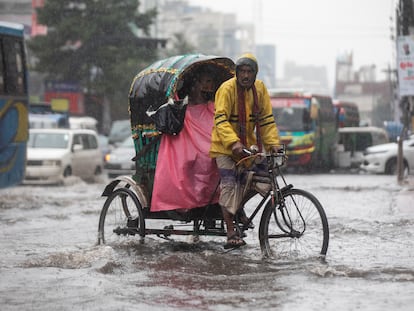 Un hombre pedaleaba en diciembre en una calle anegada por el ciclón Jawad, en Daca (Bangladés).