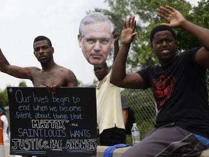 Manifestantes mostram um cartaz com o rosto do governador do Missouri, Jay Nixon.