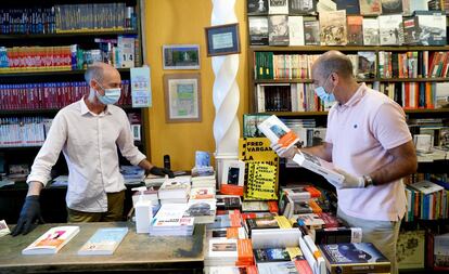 Tras  50 días de confinamiento, el pequeño comercio empieza a abrir. Uno de los más afectados, a pesar del tiempo libre que se ha tenido para leer, ha sido el de las librerías. En la imagen, un librero atiende a un cliente, ayer en San Sebastián. 