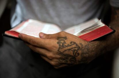 Uno de los antiguos pandilleros sostiene una Biblia durante un momento de oración.