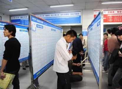 Jóvenes chinos despedidos de una fábrica buscan trabajo en una oficina de empleo de Donguan, provincia de Guandong.