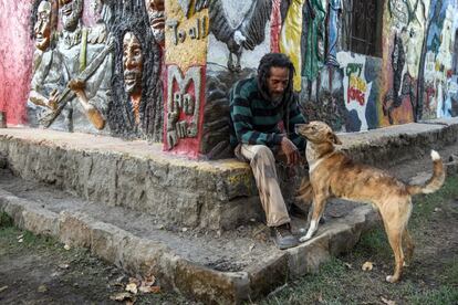 En un momento se creía que había 2.000 rastafaris viviendo en la comunidad de Shashamane, pero actualmente ese número se ha reducido a unos 300. En la imagen, Teddy Dan, artista y músico rastafari originario de Jamaica, juega con su perro frente al mural que cubre su vivienda.