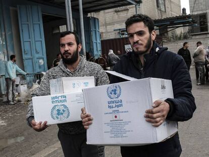 Refugiados palestinos recogen paquetes con ayuda de la ONU en Jan Yunis (Gaza).