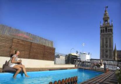 Turistas se refrescan en la piscina de un céntrico hotel sevillano frente a la Giralda. EFE/Archivo