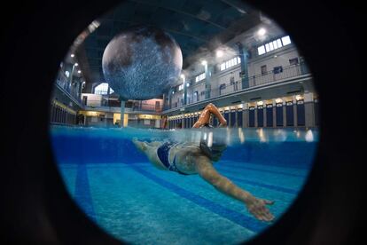 Una persona nada bajo una obra de arte 'Museo de la Luna' del artista británico Luke Jerram en la piscina de Saint-Georges, en Rennes (Francia).