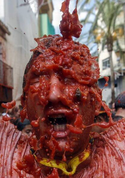 Participante con la cara cubierta de tomates en la fiesta La Tomatina en Buñol (Comunidad Valenciana).