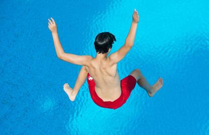 Niño, saltando a la piscina.