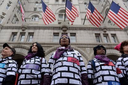 Mujeres vestidas con trajes que simulan un muro protestan frente al Hotel Trump International, mientras participan en la Tercera Marcha Anual de Mujeres en Washington.