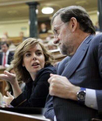 El líder del PP, Mariano Rajoy, conversa con la portavoz del PP, Soraya Sáenz de Santamaría, durante el debate sobre el estado de la nación