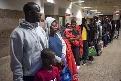 Los migrantes desplazados a la Estación Marítima de Algeciras esperan en fila con todas sus pertenencias.