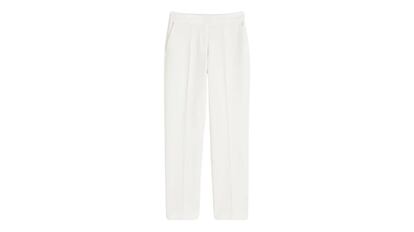 Pantalón de traje ajustado en color blanco para mujer de H&M. Elástico oculto en la cintura, cierre de cremallera y bolsillos traseros decorativos (rebajas).